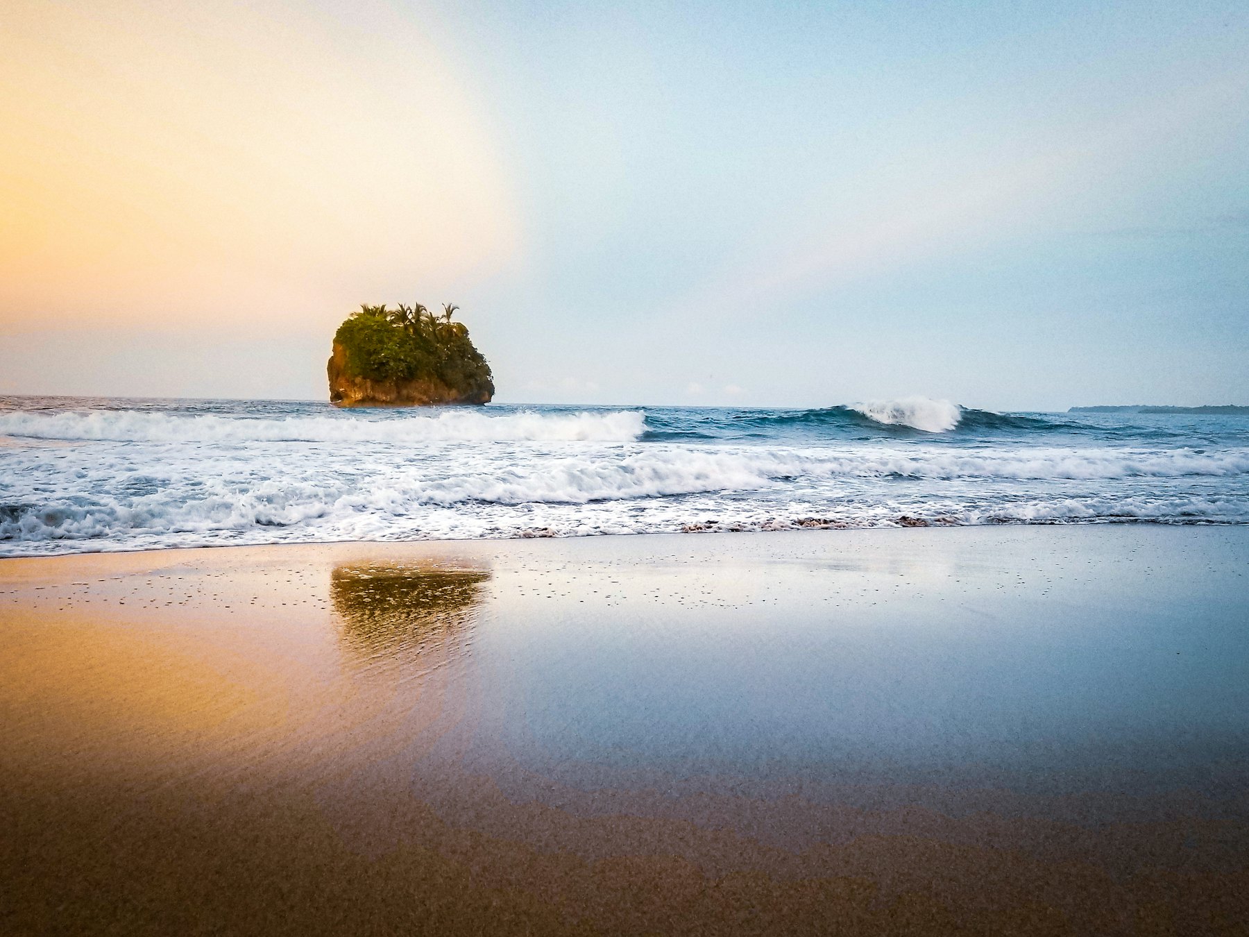 Playa amplia en Santa Teresa con un peñón frente a la costa