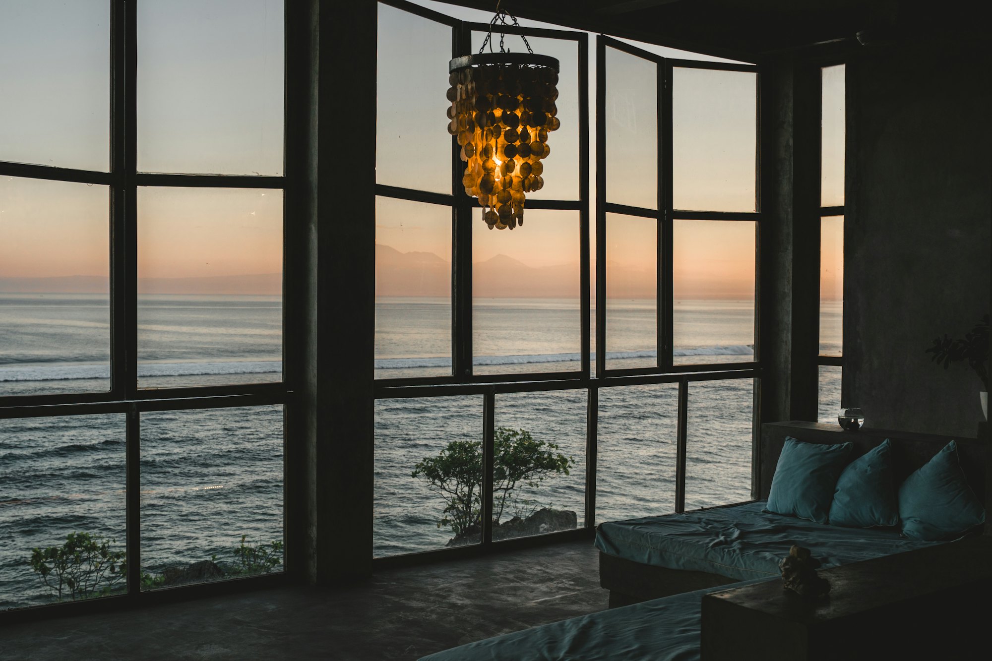 A living room opening onto the ocean at the end of the day